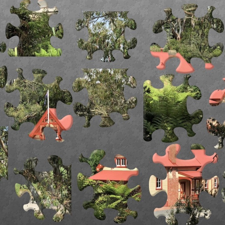 The Korumburra Courthouse broken up into jigsaw puzzle pieces, on a grey background
